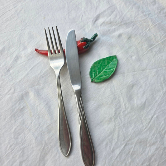 Set di poggia posate Cuore e Pennello in ceramica a forma di peperoncino rosso e foglia verde su tovaglia bianca