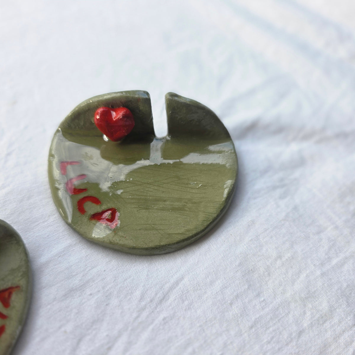 Poggia posate Cuore e Pennello in ceramica verde oliva con cuore rosso e nome personalizzato su sfondo bianco